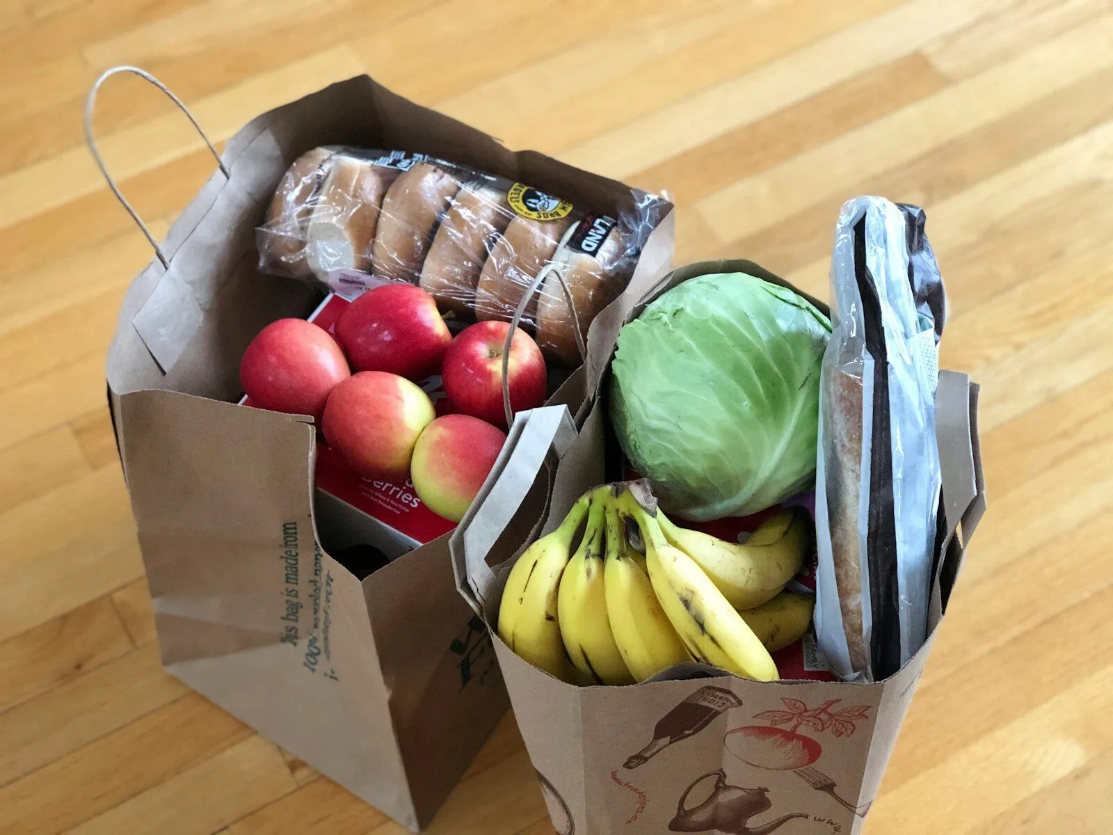 Paper grocery bags filled with fruit, vegetables and bread