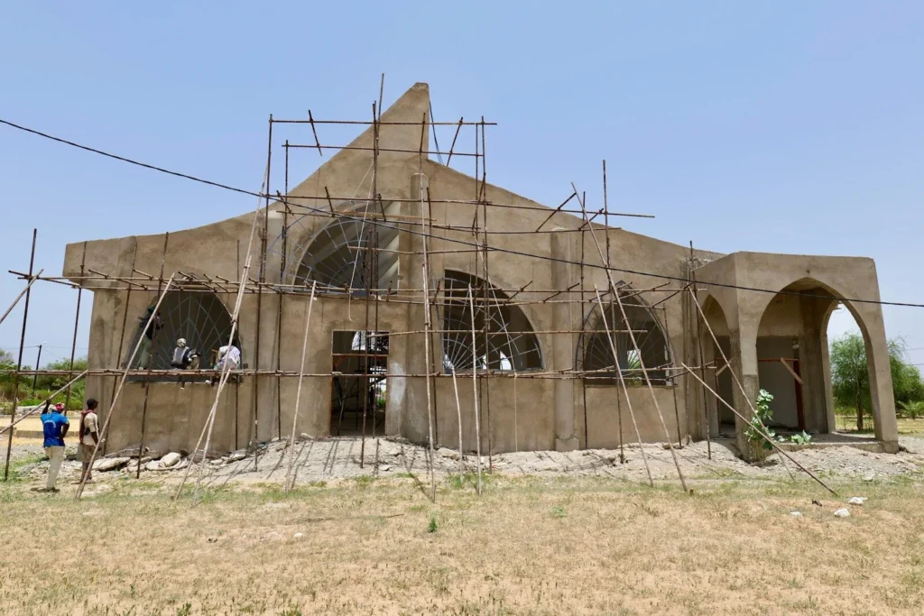 Building under construction surrounded by wooden scaffolding