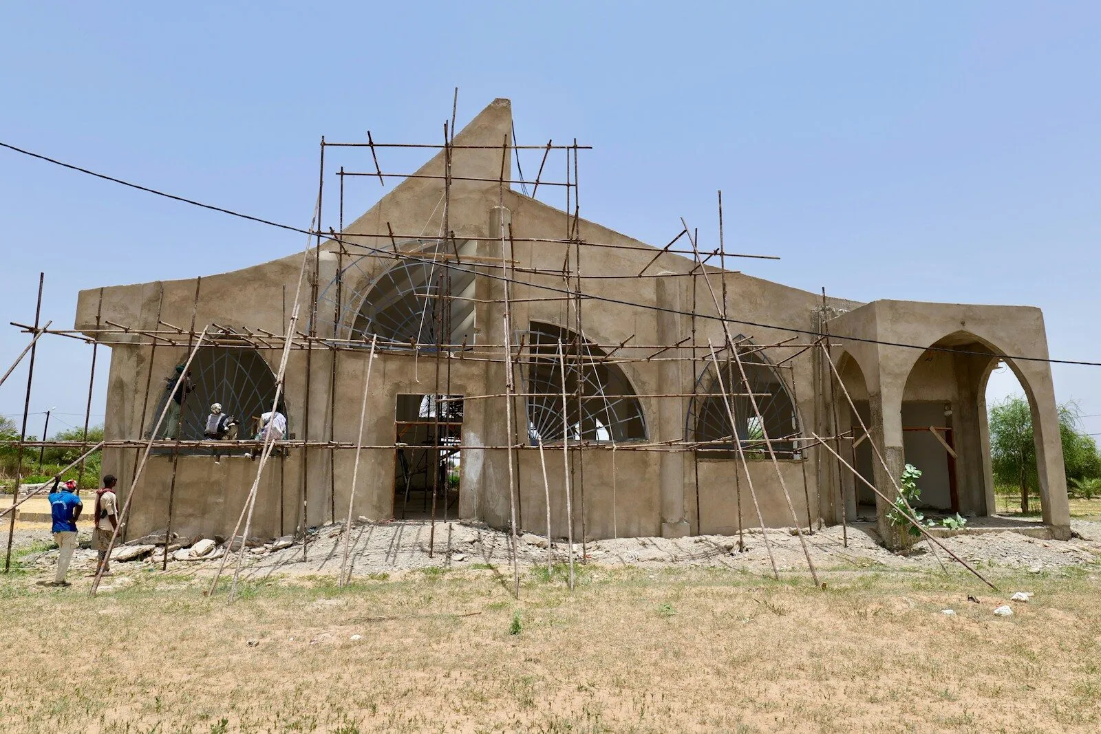 Building under construction surrounded by wooden scaffolding