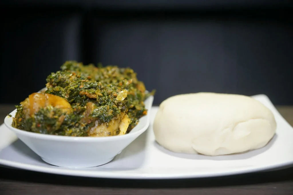 White maize-meal staple served with a bowl of leafy green relish