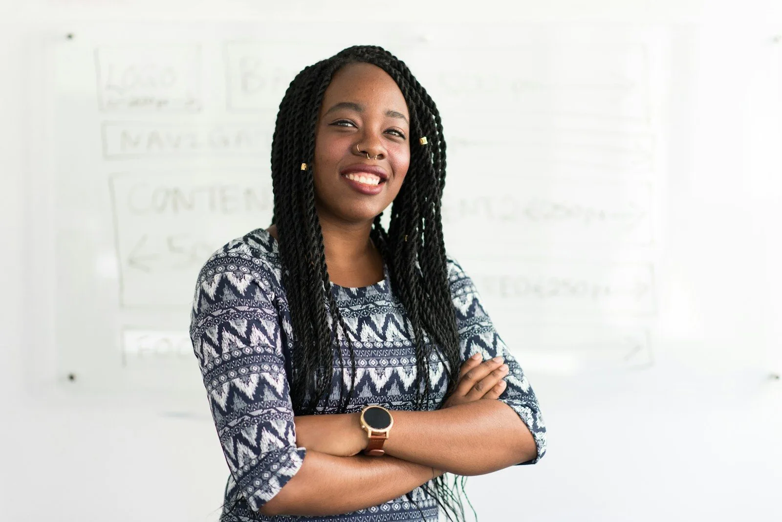 Confident entrepreneur with braids standing in her workspace