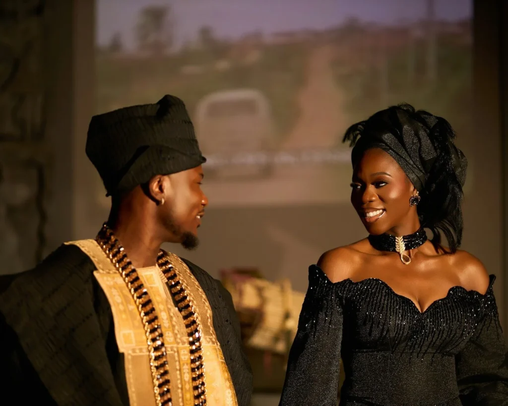 Bride and groom in traditional attire smiling at each other