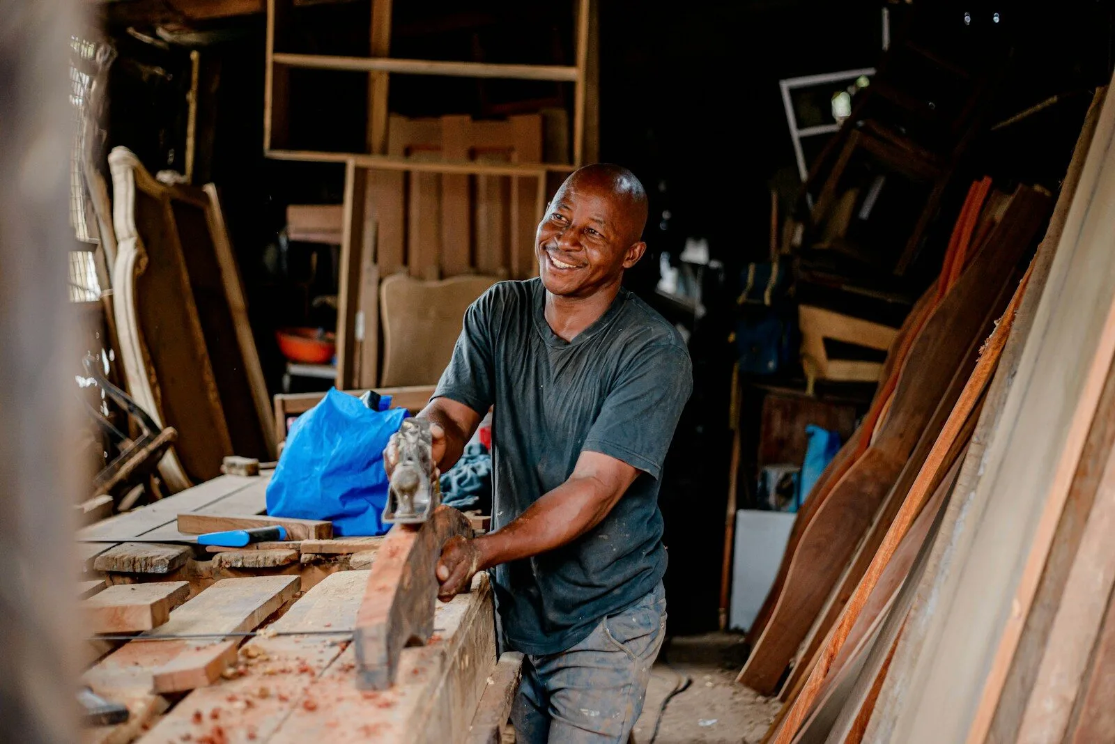 Smiling carpenter at work in his timber workshop